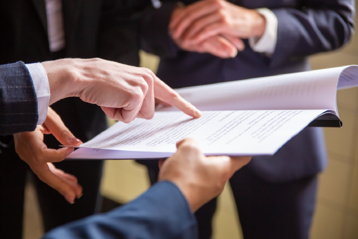 Importancia de leer y entender un contrato bancario Ejecutivos analizando un documento y señalando puntos clave