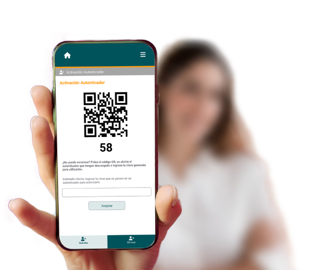 Mano sosteniendo un teléfono en primer plano que muestra un código QR, con mujer borrosa al fondo