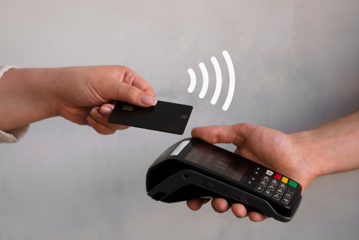 Mujer con tarjeta de crédito negra paga en un punto de venta sin contacto; destaca el ícono de la tecnología Contactless 